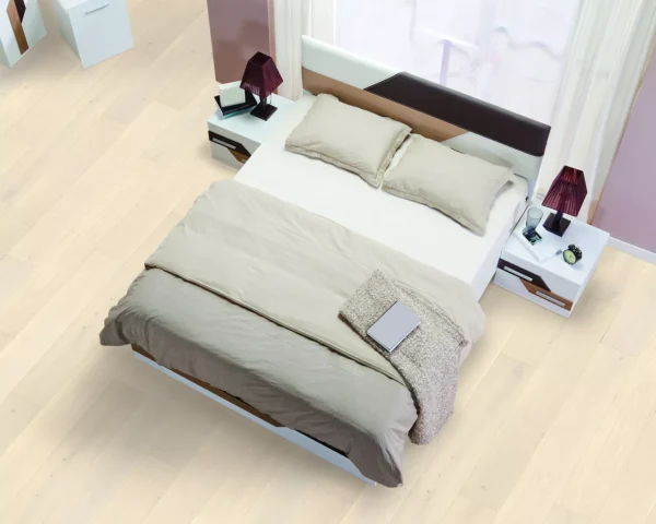 Bali hardwood flooring in a modern bedroom, featuring light wood planks beneath a neutral-toned bed.